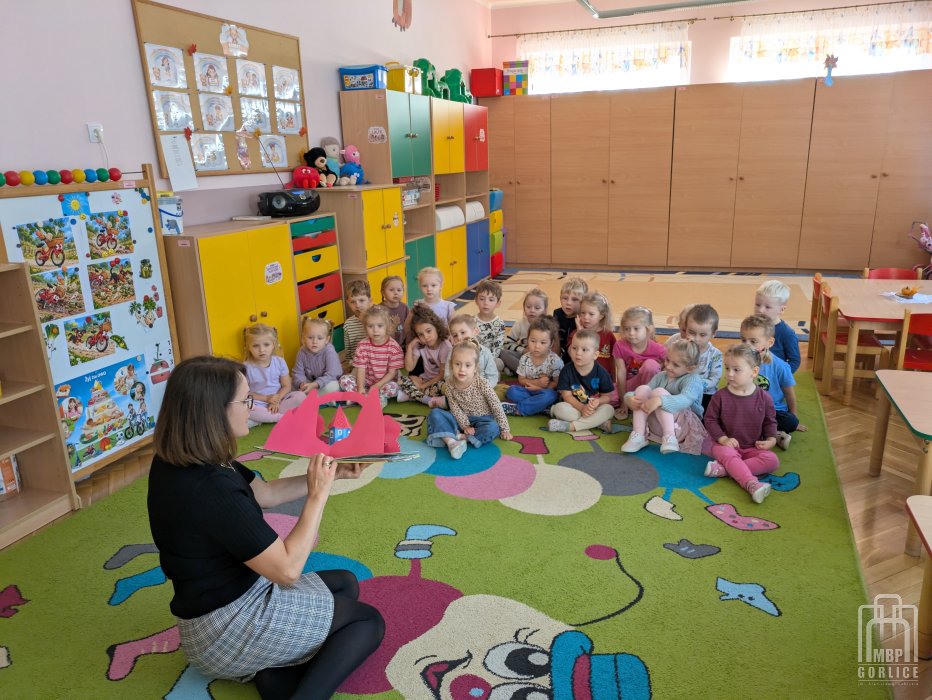 Biblioteka Gorlice, Cała Polska czyta dzieciom Bibliotekarka pokazuje dzieciom interaktywną ksiązkę o Muminkach.jpg